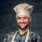 Professional male chef wearing a chef hat and apron