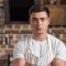 Professional male chef preparing food in a brick-walled kitchen