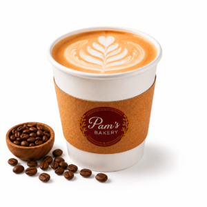 Pam’s Bakery cafe latte with leaf-shaped latte art and roasted coffee beans.