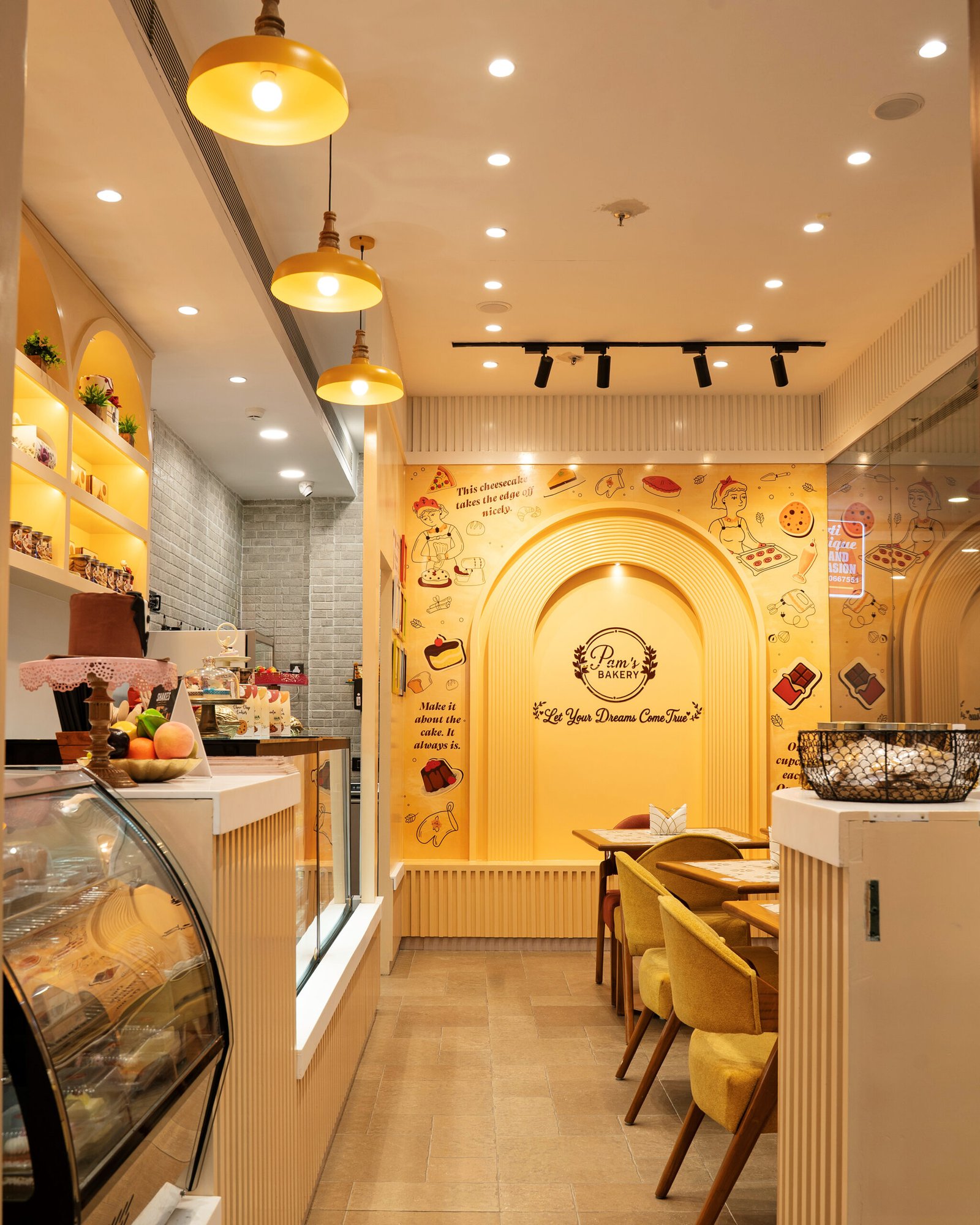 Pam’s Bakery café interior with dessert display counters, dining tables, and branded wall décor