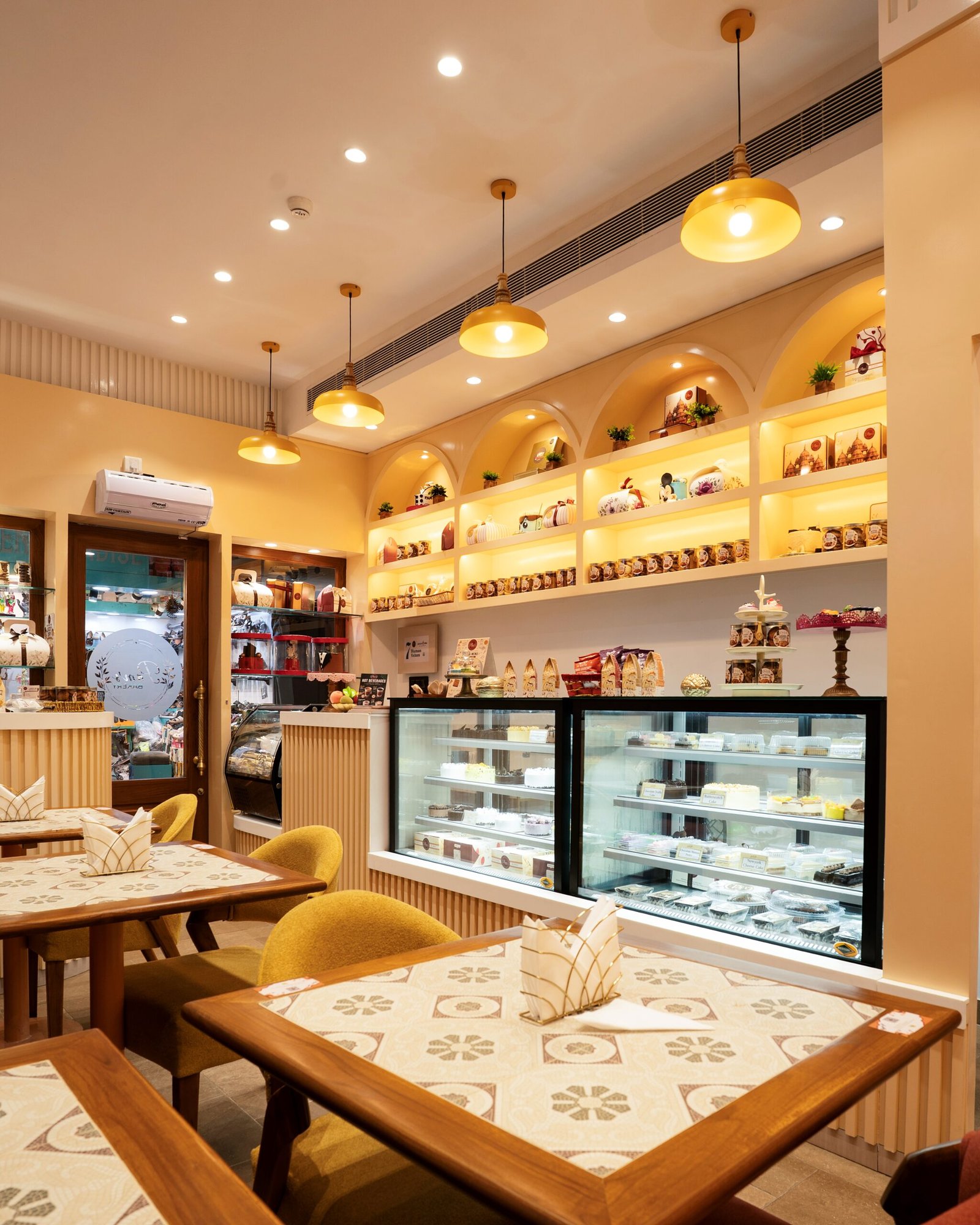 Pam’s Bakery café interior with dining tables, display counters, and shelves of bakery products