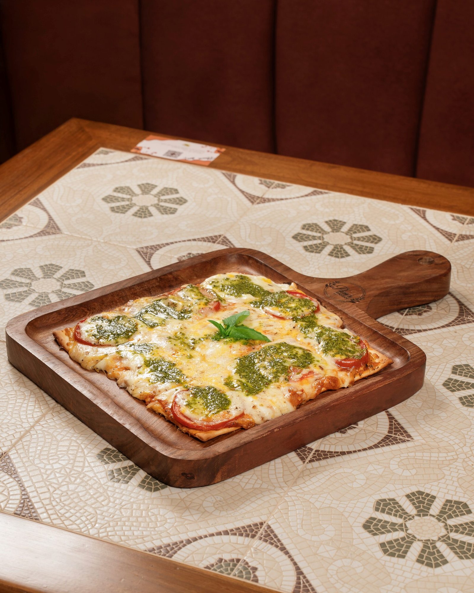 Freshly baked pesto pizza with melted cheese and herbs served at Pam's Bakery