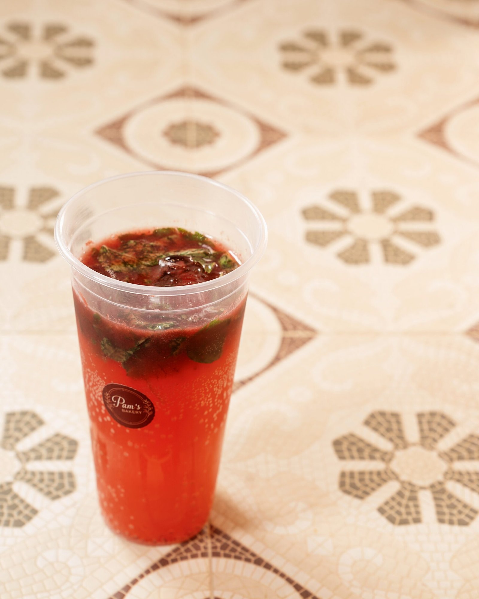 Red fizzy fruit beverage served in a branded Pam's Bakery cup