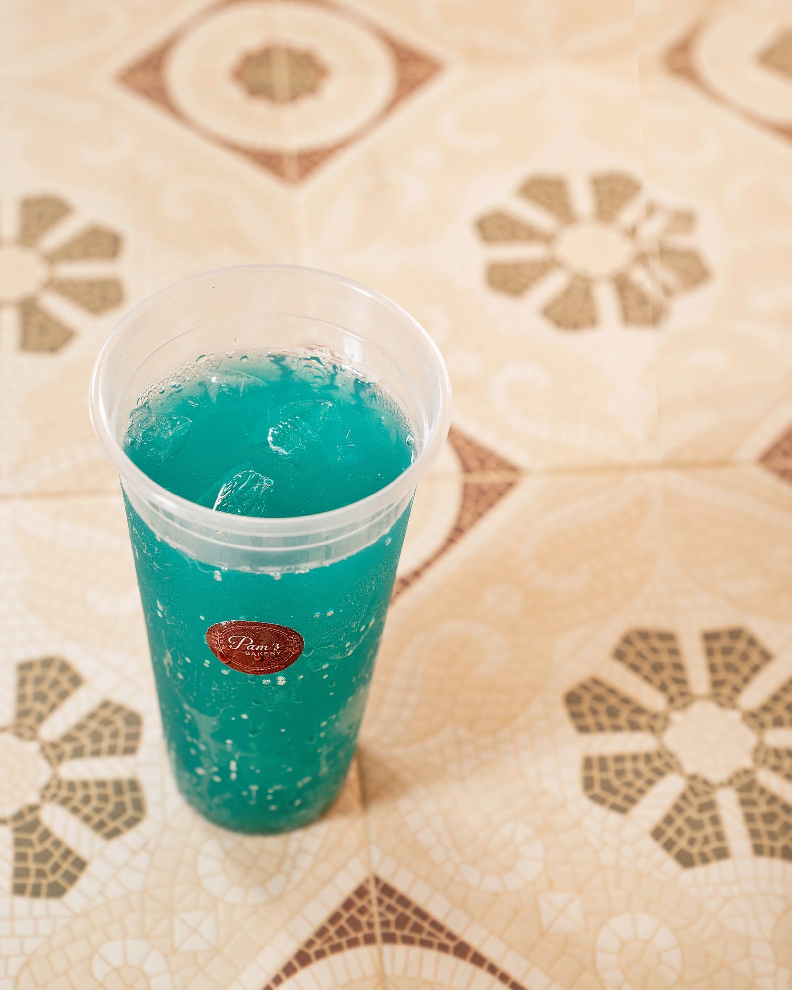 Blue fizzy beverage served in a branded Pam's Bakery cup
