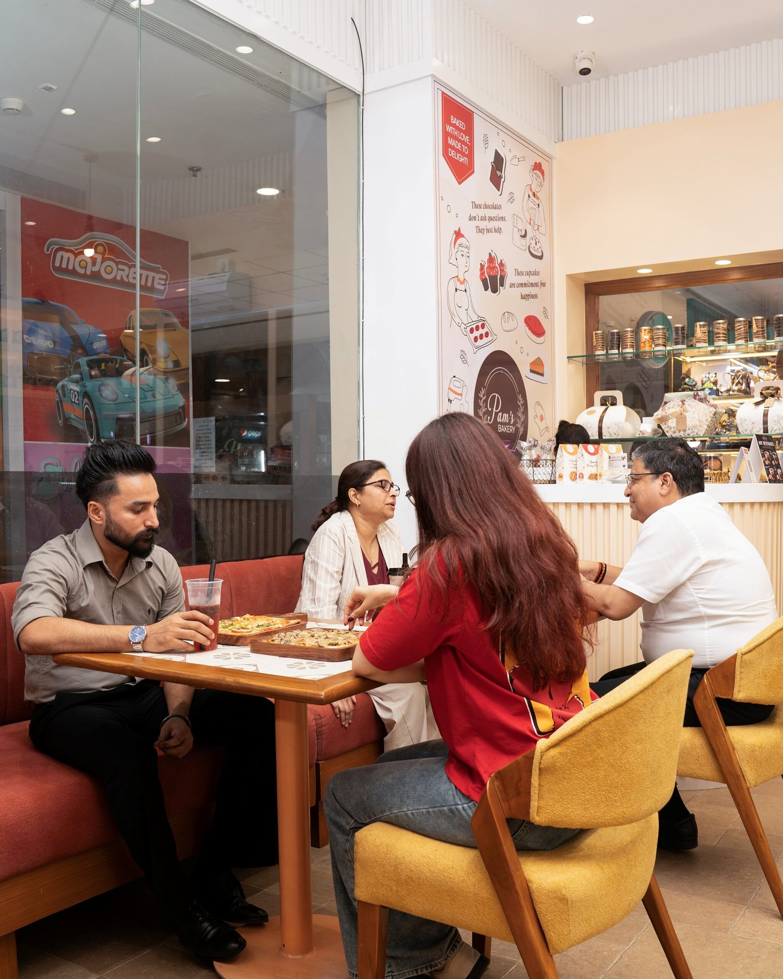 Four people enjoying food and beverages together at Pam’s Bakery café.
