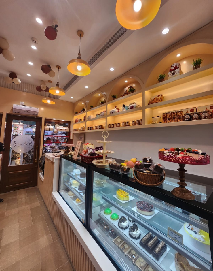 Pams Bakery Cafe interior with display counters featuring cakes, pastries, and desserts